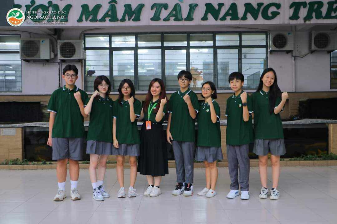 The Geography team in green uniforms, fists up, in the school yard