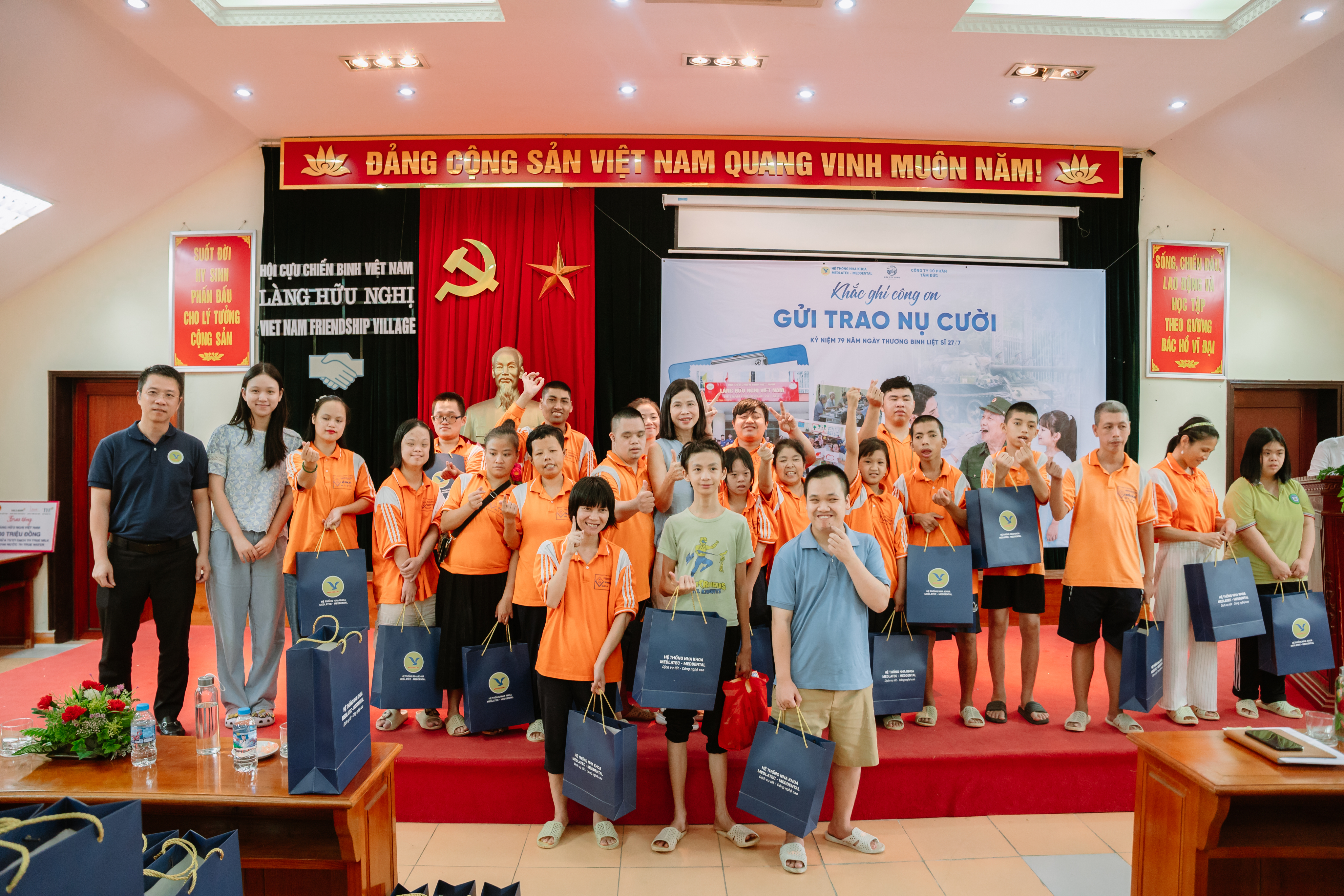 Volunteers in orange shirts handing out gift bags