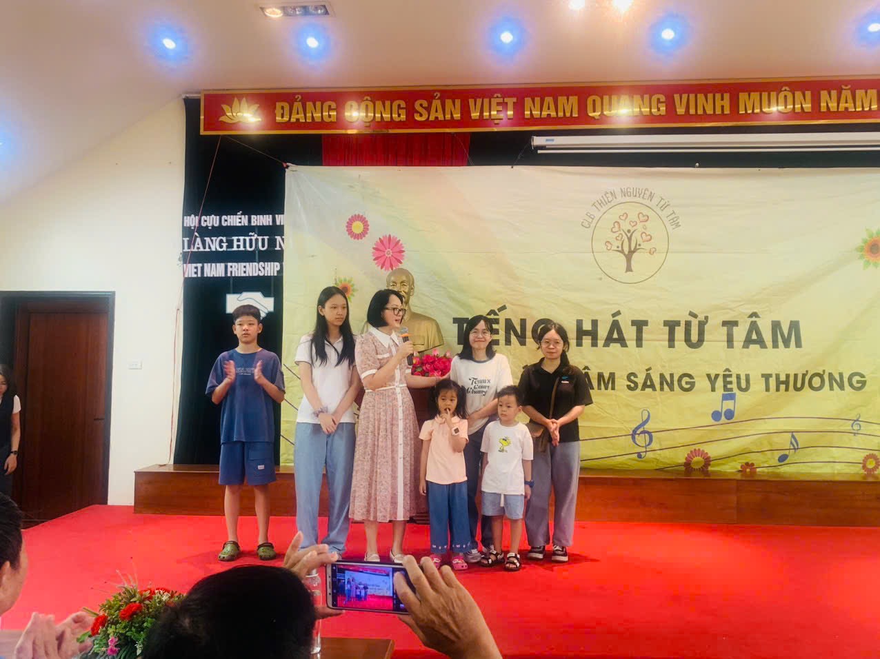 Children performing on a small stage at the village