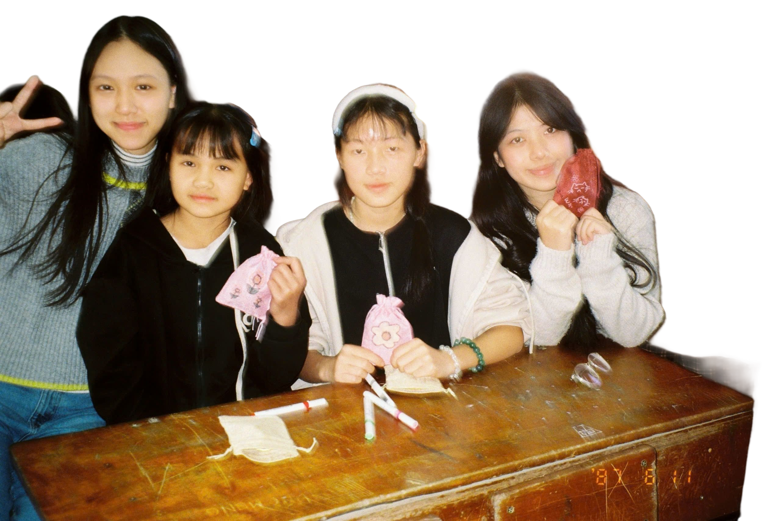 Gia Han and three friends leaning on a wooden desk