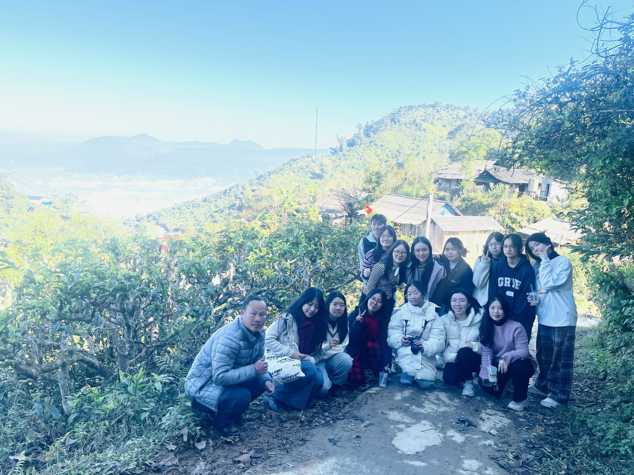 The team posing on a hillside above the clouds