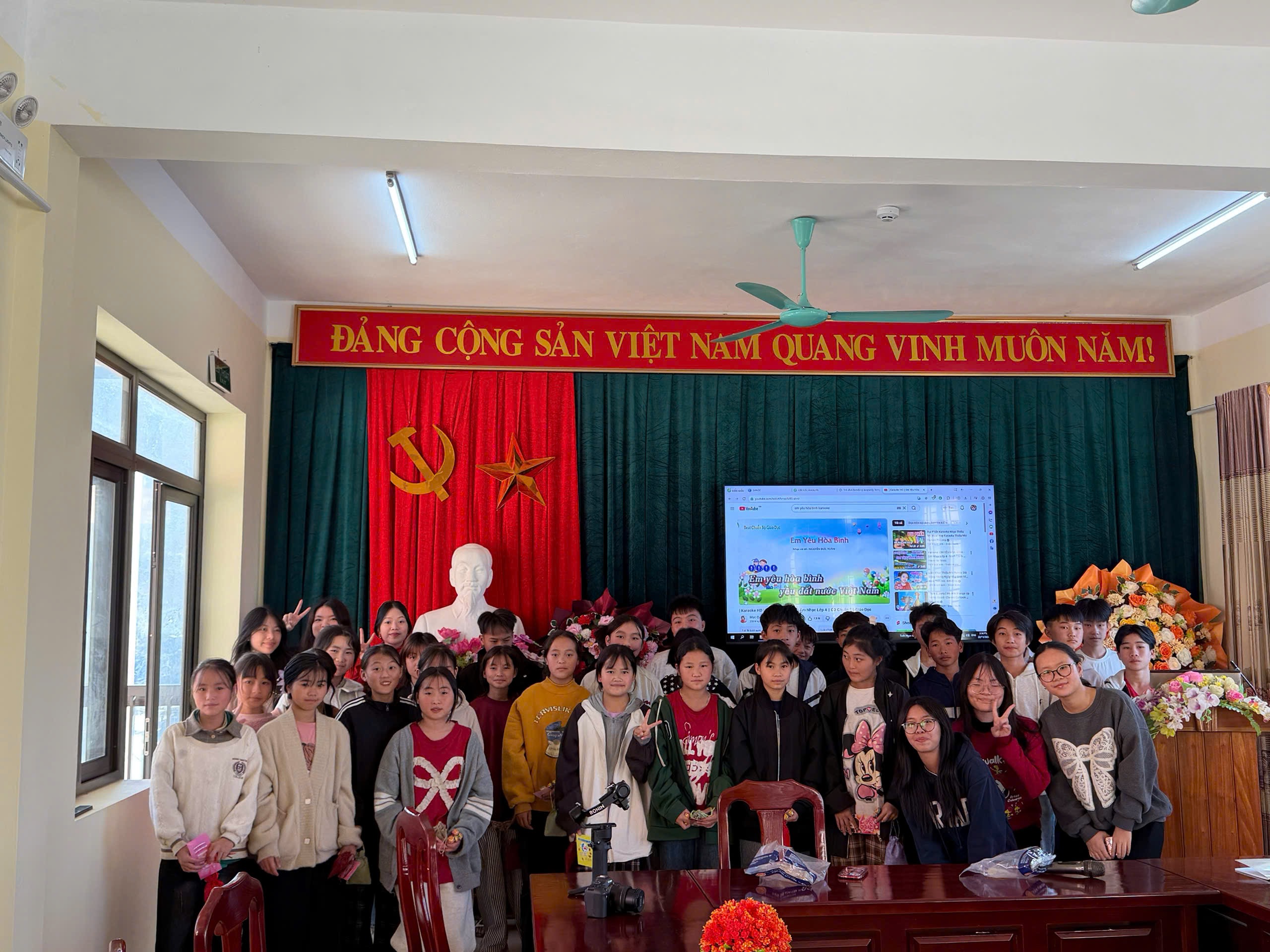 Students and teachers gathered in a school hall