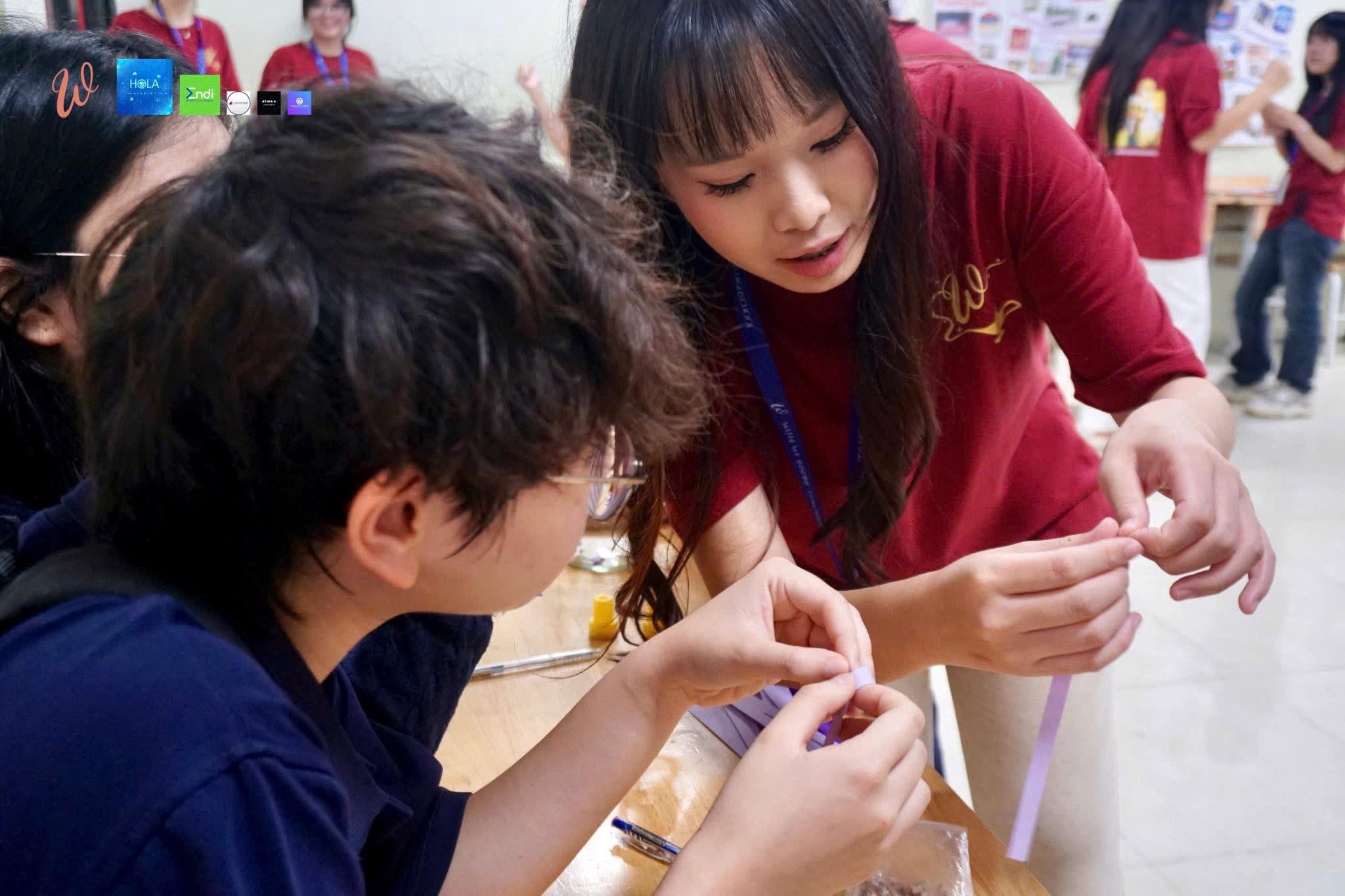 Gia Han helping a student with a craft activity